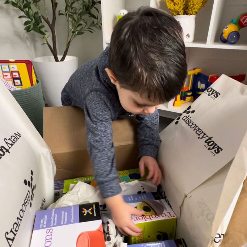 Child opening delivery box from Discovery Toys